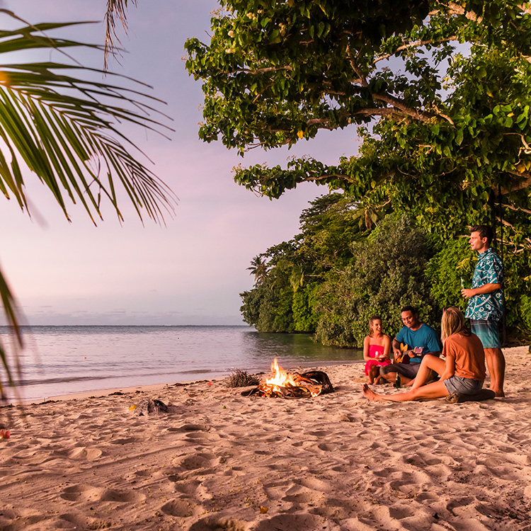 Samoa sitting around bonfire